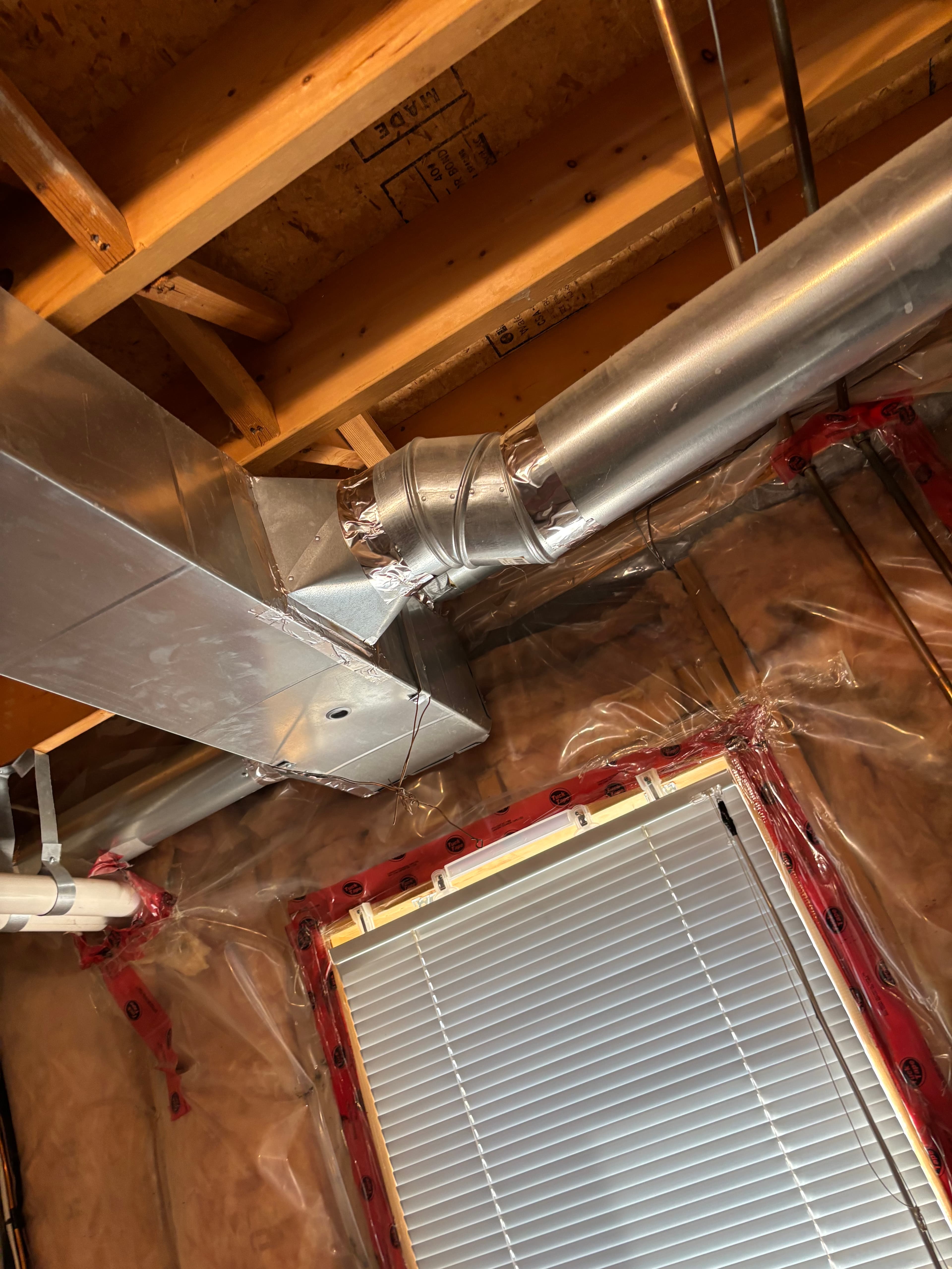 Galvanized rectangular and round ductwork installed between wood joists